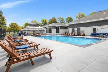 Resort style pool with lounge chairs and clubhouse